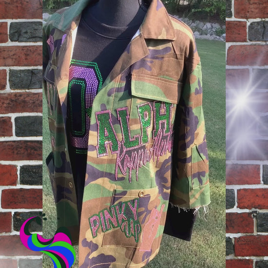 Show your Pretty Girl pride in this standout bling camo jacket – a lightweight, unlined shirt-style jacket adorned with handmade pink and green spangle patches that sparkle with purpose. Whether you're strolling through campus, heading to chapter events, or repping your legacy, this camo jacket combines style, comfort, and sorority sisterhood.
